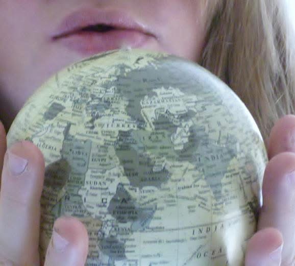 Photo of Jen Ward infusing healing energy into a miniature globe of the Earth