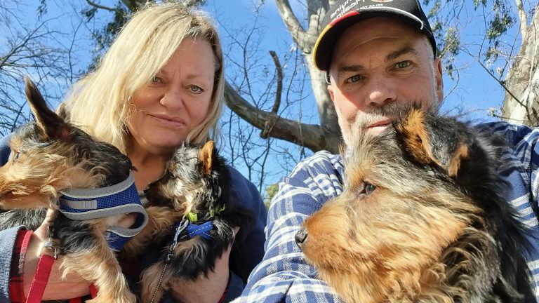 Photo of Jen Ward and Marvin Schneider with their three puppies in the park